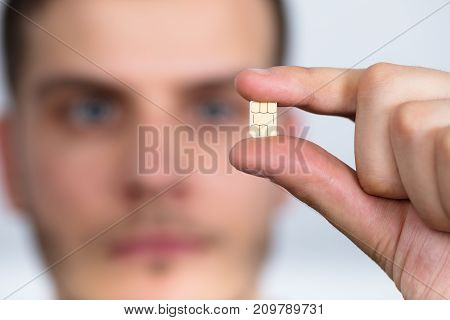 Close-up Of A Man Holding Nano Sim Card Between Fingers