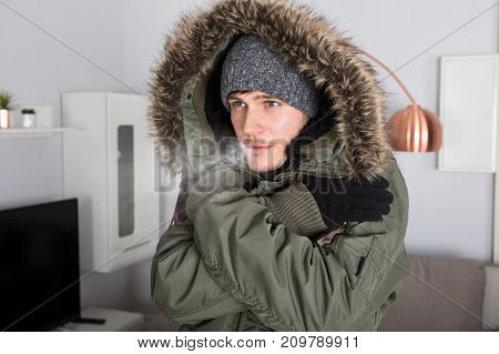 Young Man With Warm Clothing Feeling The Cold Inside House