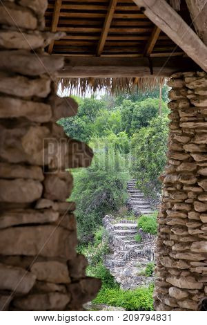 asian rock pillars and grass roof overlooking green rock garden