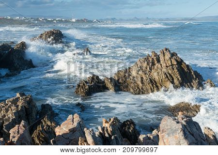 Waves crash on rocks in the fishing village of Kleinbaai near Gansbaai South Africa