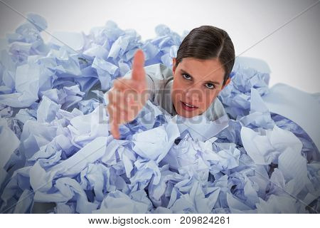 Conceptual image of woman in heap of crumple paper asking for help against grey background