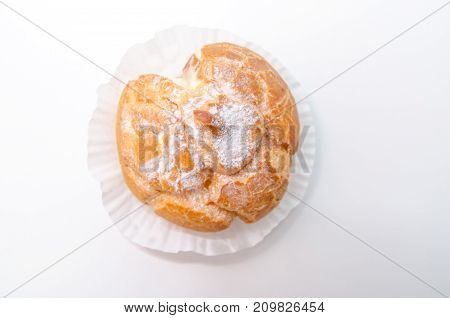 Profiteroles stuffed with pastry cream on white desk in cafe