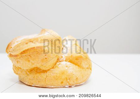 Profiteroles stuffed with pastry cream on white desk in cafe