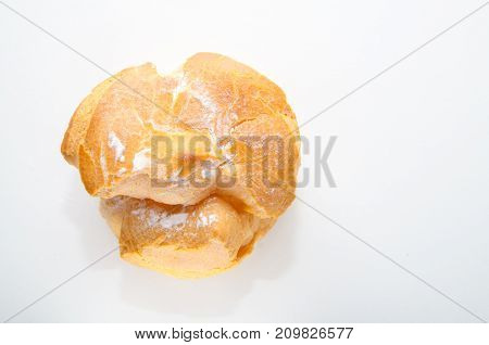 Profiteroles stuffed with pastry cream on white desk in cafe