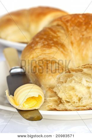 Boter curl op mes, met verse croissants.