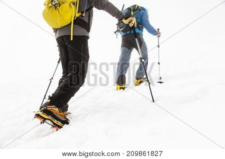 A close-up of the legs of a group climbing uphill climbing the top of Elbrus