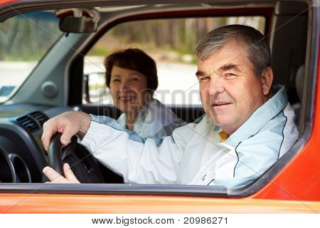男性がカメラ、車の中で彼の妻との背景に見て