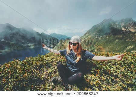 Woman meditating in mountains yoga lotus pose Travel Lifestyle adventure concept harmony with nature summer vacations outdoor