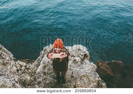 Young Woman taking selfie photo by smartphone Travel Lifestyle concept adventure vacations at sea winter beach outdoor