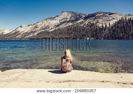 woman sitting at a lake in Yosemite Park.