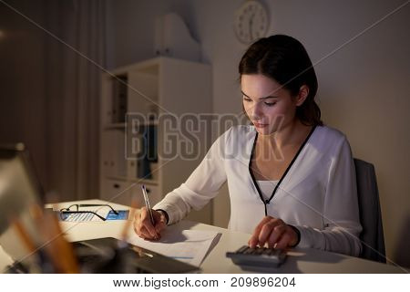 business, accounting, overwork, deadline and people concept - woman with tax form and calculator working at night office