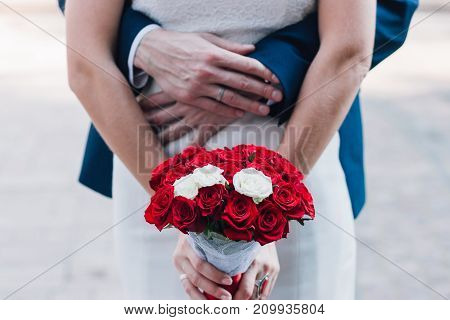 Young beautiful bride holds a bouquet hands