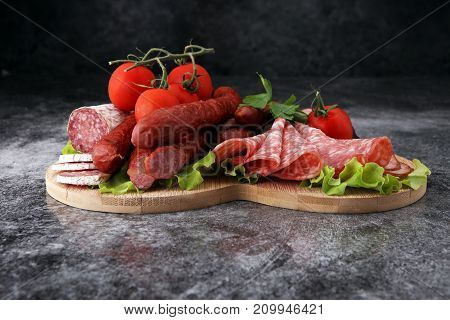 Food tray with delicious salami pieces of sliced ham sausage tomatoes salad and vegetable - Meat platter with selection - Cutting sausage and cured meat