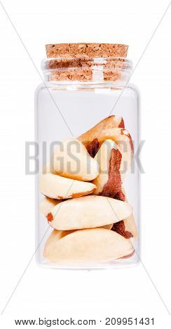 Brazil nuts in a glass bottle with cork stopper, isolated on white.