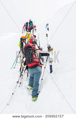 Group of cross-country skiers ascending a steep slope. Line of people in winter fairytale.