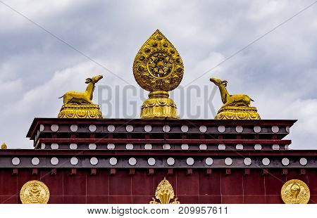 Rooftop statues of two golden deer and Dharma wheel in Songzanlin Tibetan Buddhist Monastery, Zhongdian, Yunnan - China.