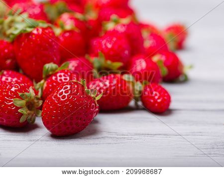 Fresh ripe fruits on a gray wooden table. Sweety red strawberries summer fruits on a gray background. Close-up of strawberry. Food concept.