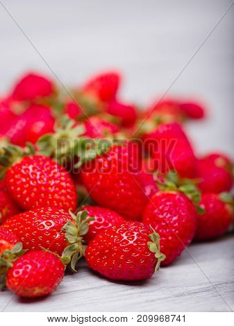 Fresh ripe fruits on a gray wooden table. Sweety red strawberries summer fruits on a gray background. Close-up of strawberry. Food concept.