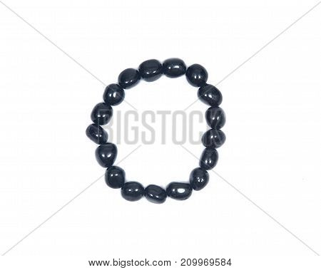 Black Tourmaline Bracelet isolated on white background. Polished tumbled black tourmaline stones strung on stretch cord.