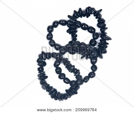 Black Tourmaline Bracelet isolated on white background. Polished tumbled black tourmaline stones strung on stretch cord.