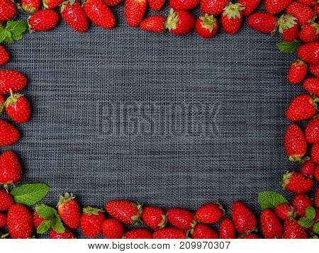 Fruit frame. Sweety red strawberries summer fruits on a gray background. Copy space. Close-up of strawberry. Food concept.