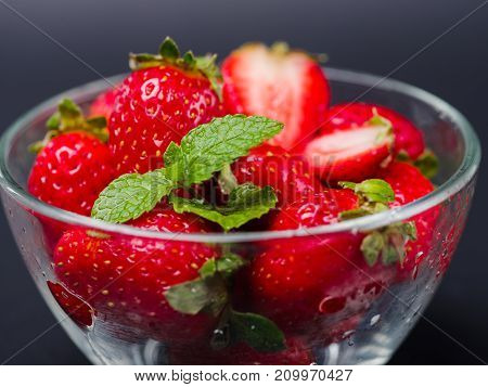 Fresh ripe fruits. Sweety red strawberries summer fruits in a glass bowl on a gray background. Copy space. Close-up of strawberry. Food concept.