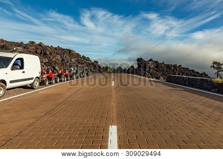 Low Posicion Shot Of Road. Sunset Time Above The Clouds In The Mountains. Roadside Buggies. Park Roa
