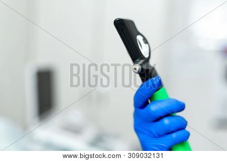 Doctor Hand In Blue Rubber Glove Hold Professional Ophthalmologist Tool Tonometer.
