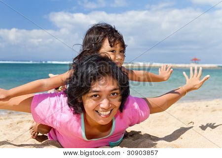 Asian madre e bambino che gioca in spiaggia