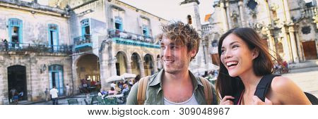 Tourists couple travel in Havana, Cuba panoramic banner. Young interracial happy couple backpacking vacation walking on Plaza de la Catedral, Old Havana.