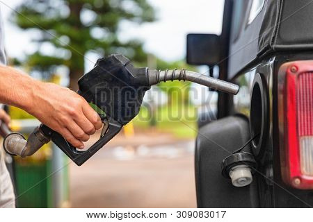 Gas station pump. Man filling gasoline fuel in car holding nozzle. Close up.