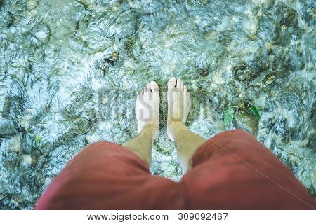 Hiking Outdoors In The Forest: Cut Out Of Male Barefoot Feet In A Shallow River, Fresh Water