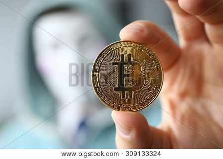Minsk, Belarus, June, 2019: Hacker Wear Anonymus Mask Hold Bitcoin In Hand Illustrative Editorial