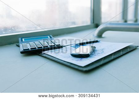 Calculator, Smartphone And Financial Documents On The Businessm