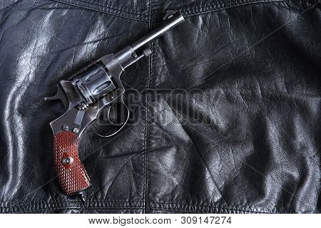 Old Revolver On Black Leather Background With Free Space