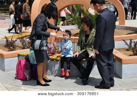 Pyongyang, North Korea - May 1, 2019: A Family Of Locals Rests In The Taesongsan Funfair. Is An Amus