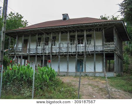 Old Wooden Village House In Iran. Beautiful Rural House With Gable Roofs And Wooden Porch In Front O