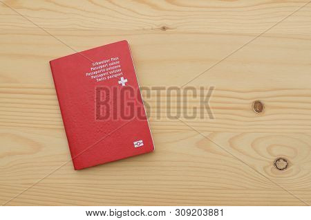 Top View Of A Single Swiss Passport On A Wooden Table