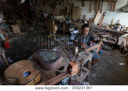 Gianyar,bali/indonesia-may 30 2019: A Guitar Craftsman Is Measuring And Make Sure It Is A Precision