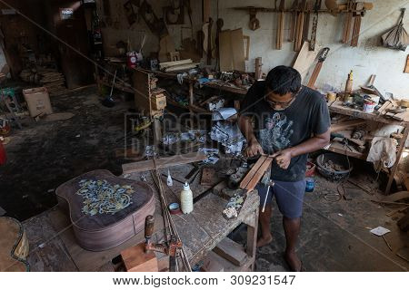 Gianyar,bali/indonesia-may 30 2019: A Guitar Craftsman Is Measuring And Make Sure It Is A Precision