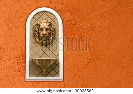 Lion Head Statue On Cavernous Stone Wall. Concept Decoration Architecture Sculpture Low Relief Ornam