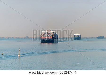 Suez, Egypt - November 5, 2017: Large Container Vessels (ships) Passing Suez Canal In The Sandy Haze