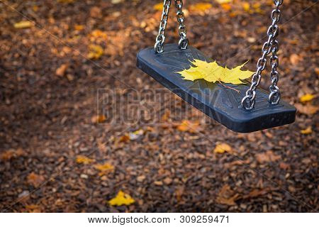 Autumn, A Lone Leaf Rests On A Swing.