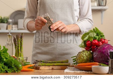 Close-up, Chef Peppers Asparagus, With Vegetables On A Light Background. A Concept Of Losing Healthy