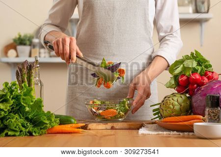 The Chef Prepares A Fresh And Bright Salad, With Vegetables On A Light Background. The Concept Of Lo