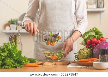The Chef Prepares A Fresh And Bright Salad, With Vegetables On A Light Background. The Concept Of Lo
