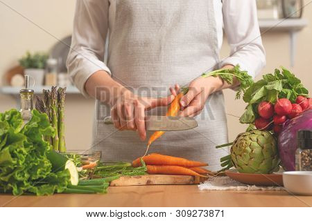 The Chef Cuts Fresh Carrots For Salad. The Concept Of Losing Healthy And Wholesome Food, Detox, Vega