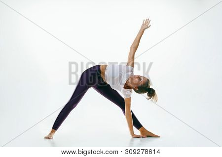 Sporty Young Woman Doing Yoga Practice Isolated On White Studio Background. Fit Flexible Female Mode
