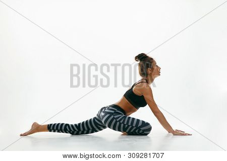 Sporty Young Woman Doing Yoga Practice Isolated On White Studio Background. Fit Flexible Female Mode