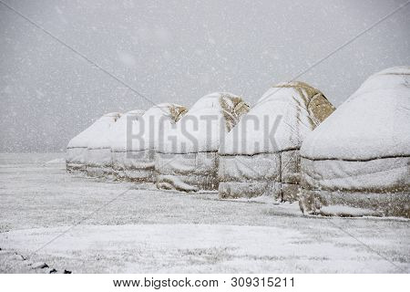 Yurt Under The Snow In The Middle Of A Snow-covered Field. Travel Kyrgyzstan.